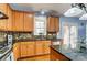 Modern kitchen with wooden cabinets, granite countertops, stylish backsplash, stainless steel appliances, and hardwood floors at 5807 Mctaggart Ln, Charlotte, NC 28269