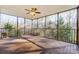 Large screened porch with wood flooring, offering an inviting outdoor living space surrounded by trees at 5807 Mctaggart Ln, Charlotte, NC 28269