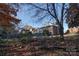 Overgrown backyard with mature trees and brick fence at 610 Hawthorne Ln, Charlotte, NC 28204