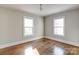 Bedroom showcasing hardwood floors, neutral walls, and natural light from two windows at 610 Hawthorne Ln, Charlotte, NC 28204