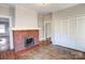 Living room featuring a brick fireplace, hardwood floors, and ample closet space at 610 Hawthorne Ln, Charlotte, NC 28204