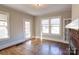 Living room showcasing hardwood floors, a brick fireplace, and natural light from three windows at 610 Hawthorne Ln, Charlotte, NC 28204