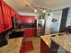 Well-appointed kitchen with red cabinetry, granite countertops, stainless steel appliances and black tile backsplash at 8603 Westhope St, Charlotte, NC 28216