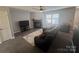 Comfortable living room featuring gray sofa, modern fireplace, and neutral decor with tile floors at 8603 Westhope St, Charlotte, NC 28216