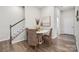 Cozy dining area with a round table, woven chairs, and a staircase in a neutral color palette at 8635 Miles Gap Rd, Indian Land, SC 29707