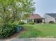 Lush backyard with mature trees, a golf course view, and a charming covered patio area at 9607 Kestral Ridge Dr, Charlotte, NC 28269