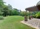 Pergola overlooking the lush green backyard with mature trees and a well-maintained lawn at 9607 Kestral Ridge Dr, Charlotte, NC 28269