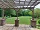 Backyard featuring a pergola-covered patio with view of the well-manicured lawn and landscaping at 9607 Kestral Ridge Dr, Charlotte, NC 28269