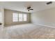 Spacious carpeted bedroom with a ceiling fan and multiple windows for ample natural light at 9607 Kestral Ridge Dr, Charlotte, NC 28269