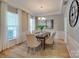 Formal dining room with modern chandelier, wainscoting, and neutral color palette at 9607 Kestral Ridge Dr, Charlotte, NC 28269