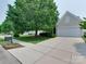 Welcoming home exterior featuring a wide driveway, two-car garage, and meticulously landscaped front yard at 9607 Kestral Ridge Dr, Charlotte, NC 28269