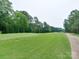 Picturesque view of a well-manicured golf course surrounded by mature trees and lush green grass at 9607 Kestral Ridge Dr, Charlotte, NC 28269