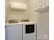 Laundry room featuring a washer and dryer, upper cabinets, and wire shelf at 9607 Kestral Ridge Dr, Charlotte, NC 28269