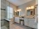 Main bathroom featuring double sinks, seated vanity, enclosed glass shower, and neutral paint at 9607 Kestral Ridge Dr, Charlotte, NC 28269