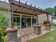 Screened patio area with stone floor, wood pergola, and lovely view of the outdoor space at 9607 Kestral Ridge Dr, Charlotte, NC 28269