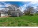 The backyard has a grassy lawn, trees, a neighboring house, and blue sky overhead at 1001 Craven Ave, Kannapolis, NC 28083