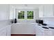Bright kitchen with white cabinets, appliances, and a view of the backyard through the windows above the sink at 1001 Craven Ave, Kannapolis, NC 28083