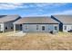 A view of the backyard featuring a blue house and dry grass at 1032 Barnette Farm Ln, Monroe, NC 28110