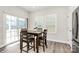 Bright dining area with a wood table, seating for four, large windows, and a sliding glass door at 1032 Barnette Farm Ln, Monroe, NC 28110