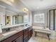 A stunning bathroom with dark wood cabinets, granite countertop, a soaking tub, and a separate shower at 10547 Skipping Rock Nw Ln, Concord, NC 28027