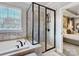 Bright bathroom features soaking tub, glass enclosed shower and a view into the bedroom at 10547 Skipping Rock Nw Ln, Concord, NC 28027
