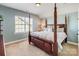 Bedroom with an ornate four-poster bed and window providing natural light at 10547 Skipping Rock Nw Ln, Concord, NC 28027