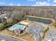 Aerial view showcasing community pool, volleyball court, playground, and pond at 10547 Skipping Rock Nw Ln, Concord, NC 28027