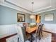 Elegant dining room featuring a modern chandelier, wainscoting, and a large window at 10547 Skipping Rock Nw Ln, Concord, NC 28027