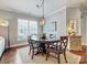 Cozy dining room with round wooden table, upholstered chairs, and ample natural light from large windows at 10547 Skipping Rock Nw Ln, Concord, NC 28027