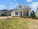 Inviting two-story home with a well-maintained lawn and covered front porch seating area at 10547 Skipping Rock Nw Ln, Concord, NC 28027