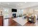 Bright living room with fireplace, large windows, hardwood floors, and comfortable neutral furniture at 10547 Skipping Rock Nw Ln, Concord, NC 28027