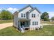 Two-story home with gray siding, covered porch, visible foundation, and equipment on the side at 106 Desert Sky Ct, Statesville, NC 28625