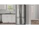 A stainless steel refrigerator in a kitchen with white cabinets and subway tile backsplash at 106 Desert Sky Ct, Statesville, NC 28625