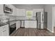 Bright kitchen with white cabinets, subway tile backsplash, and stainless steel appliances at 106 Desert Sky Ct, Statesville, NC 28625