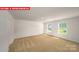 Bright bedroom featuring neutral carpet, two windows, and closet at 11135 Cardinal Creek Ave, Charlotte, NC 28215