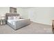 Relaxing bedroom with a gray bed, carpet, and minimalist decor for serene comfort at 11135 Cardinal Creek Ave, Charlotte, NC 28215