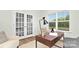 Bright office space with a modern desk, chair, rug and French doors at 11135 Cardinal Creek Ave, Charlotte, NC 28215
