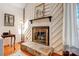 Close-up of the stone fireplace with a wood mantel and hearth, with charming design at 1119 Palmyra Dr, Tega Cay, SC 29708