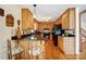 Well-lit kitchen with wooden cabinetry, black appliances, and breakfast bar seating at 1119 Palmyra Dr, Tega Cay, SC 29708