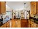 A well-lit kitchen with warm wood cabinets, granite countertops, and an adjacent dining area at 1119 Palmyra Dr, Tega Cay, SC 29708