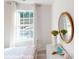 Serene bedroom with a dresser, round mirror, and a large window at 11216 Cardinal Creek Ave, Charlotte, NC 28215