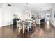 Open-concept dining area with modern light fixture, wood floors and view of white kitchen at 120 Keats Aly, Cramerton, NC 28032