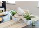 Decorated dining table featuring a ceramic bird on a pedestal, flanked by small ferns at 120 Keats Aly, Cramerton, NC 28032