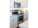Modern kitchen with stainless steel appliances, gray cabinets, and light countertops at 120 Keats Aly, Cramerton, NC 28032