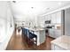 Open-concept kitchen with gray cabinets, granite countertops, stainless steel appliances, and view to living room at 120 Keats Aly, Cramerton, NC 28032