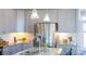 Well lit kitchen features stainless steel appliances, gray cabinets, granite countertops, and pendant lighting at 120 Keats Aly, Cramerton, NC 28032