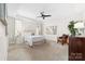 Cozy main bedroom with plush carpet, neutral walls, tray ceilings, and natural light from a large window at 120 Keats Aly, Cramerton, NC 28032
