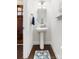 Charming powder room with pedestal sink, oval mirror, and dark hardwood floors at 120 Keats Aly, Cramerton, NC 28032