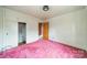 Cozy bedroom featuring pink carpet, white walls, and built in closet with door to another room at 1400 Russell Ave, Charlotte, NC 28216