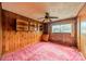 Bedroom featuring wood paneling, built-in shelving, and a ceiling fan at 1400 Russell Ave, Charlotte, NC 28216